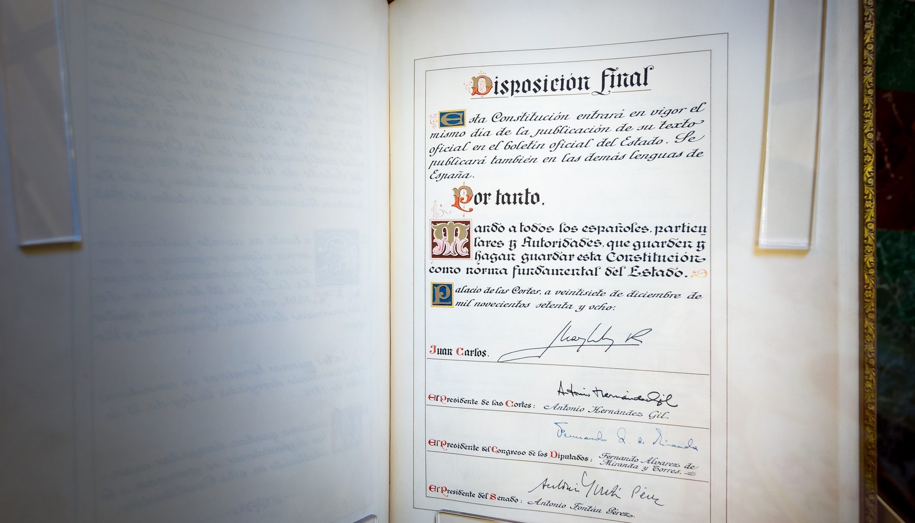 The original copy of the 1978 Constitution, displayed in the Congress of Deputies in Madrid, open at the final page signed on 27 December 1978 by the King and by the presidents of the Cortes, the Congress and the Senate.