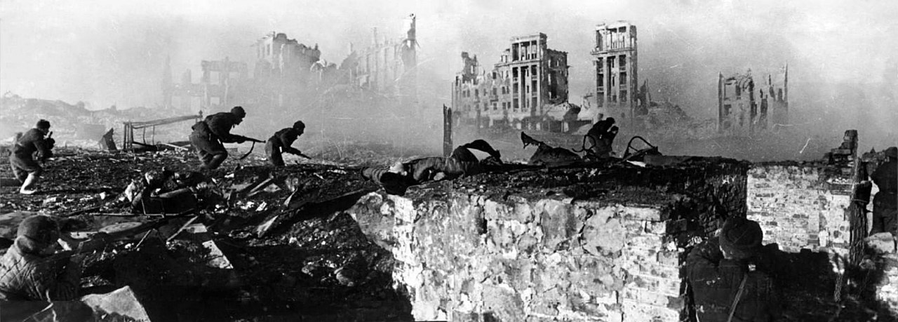 Black and white photograph of Allied soldiers landing on a beach under fire during the Normandy landings, June 1944.