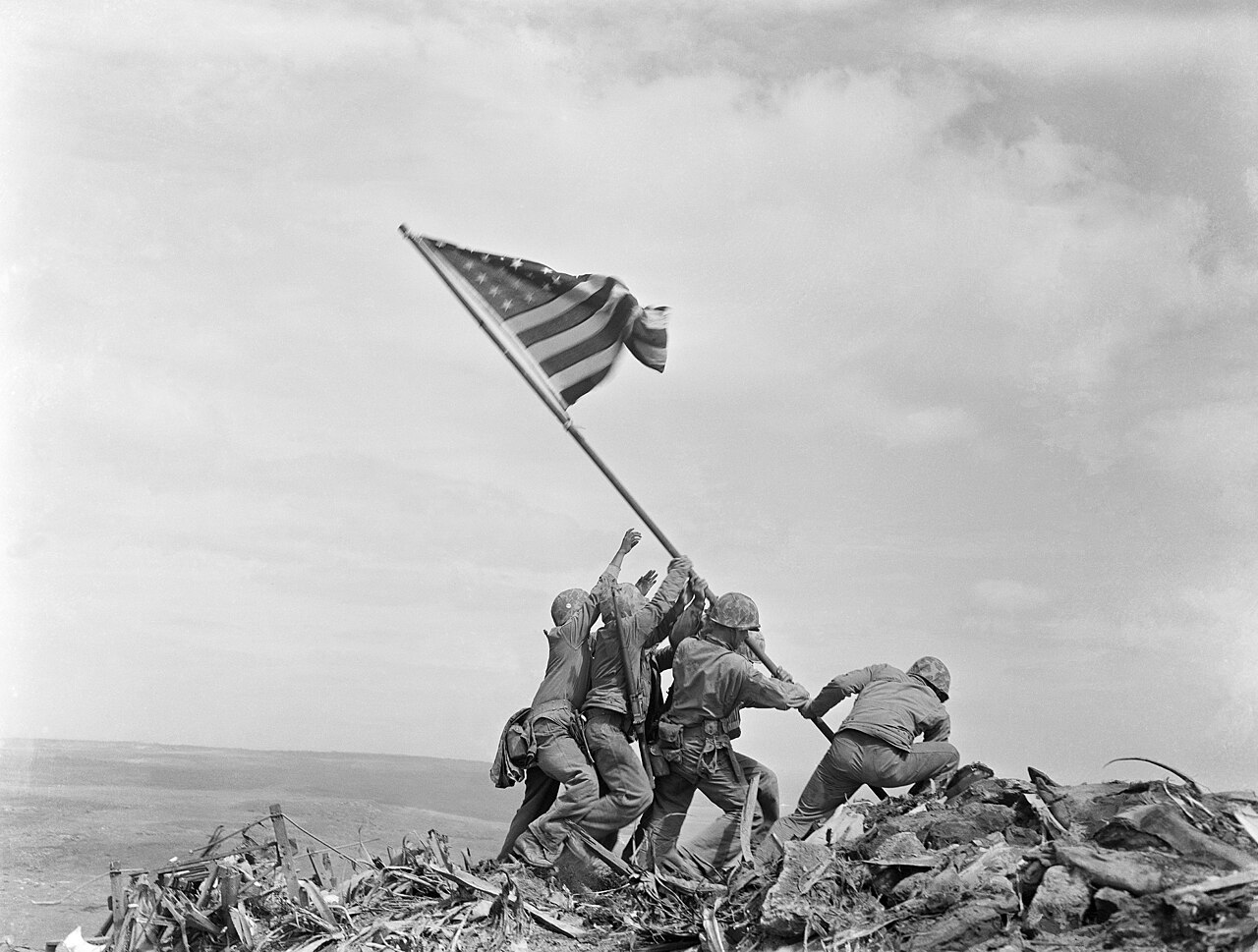 Black and white photograph of Allied soldiers landing on a beach under fire during the Normandy landings, June 1944.